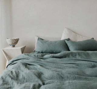 A collection of pure linen bedding, featuring linen flat and fitted sheets, duvet covers and linen pillowcases in neutral and earthy colours - all available from Arkaim Home.