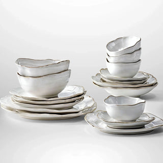 Hand-glazed ceramic plates and bowls with a soft organic shape and hand-painted rim, ideal for serving meals in an elegant, modern table setting.