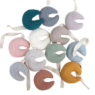 Handmade crochet moon pacifier clip in soft cotton yarn, attached to a pacifier—gentle and soothing for babies, styled in a natural nursery setting.