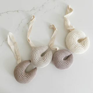 Handmade crochet moon pacifier clip in soft cotton yarn, attached to a pacifier—gentle and soothing for babies, styled in a natural nursery setting.