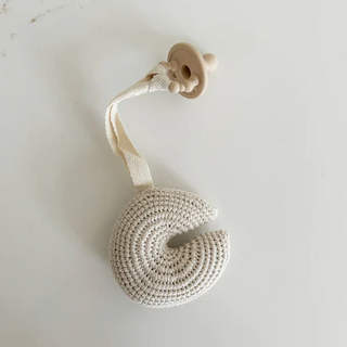 Handmade crochet moon pacifier clip in soft cotton yarn, attached to a pacifier—gentle and soothing for babies, styled in a natural nursery setting.