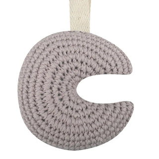 Handmade crochet moon pacifier clip in soft cotton yarn, attached to a pacifier—gentle and soothing for babies, styled in a natural nursery setting.