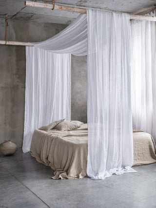 Arkaim Home – Folded natural linen textiles in soft earthy tones styled for a calm, minimal bedroom
