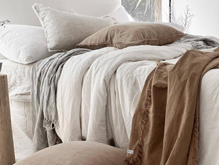 Arkaim Home – Linen bedding and natural homeware including jute, rattan and ceramic pieces in a serene bedroom setting