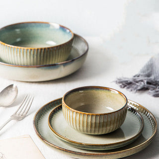 Arkaim Home – Handcrafted ceramic tableware including plates and bowls in neutral tones on a styled dining table