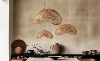 Rattan pendant ceiling lights with organic form, hanging above a rustic wooden table in a wabi-sabi dining room.