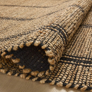 Close up of a hand-braided jute and cotton rug with a textured, two-tone weave in neutral beige and black.