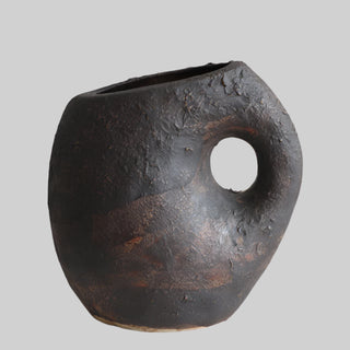Nara handmade ceramic ornamental vase with an organic, asymmetrical shape and a textured blackened clay finish with bronze undertones. The vase features a sculptural handle-like cutout and a rustic, wabi-sabi aesthetic. Perfect for Japandi, modern, and minimalist home décor.