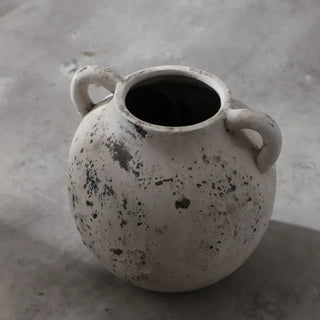 Handmade distressed white ceramic vase. The vase features a classic shape with 2 small handles and a distressed finish which exudes rustic charm. It complements contemporary, scandi, rustic or boho home décor. A lovely decorative accessory inspired by nature.