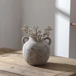Handmade distressed white ceramic vase. The vase features a classic shape with 2 small handles and a distressed finish which exudes rustic charm. It complements contemporary, scandi, rustic or boho home décor. A lovely decorative accessory inspired by nature.