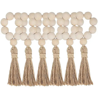 Set of six handmade wood bead napkin rings with whitewashed wood and hemp rope tassels, perfect for natural and eco-styled table settings.