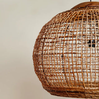Handwoven abaca pendant light with rounded shape and reclaimed teak top—natural, organic lighting for contemporary interiors.
