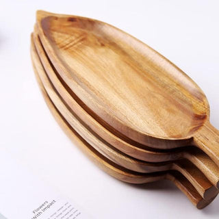 Leaf-shaped acacia wood serving tray, showcasing natural grain and carved detail.