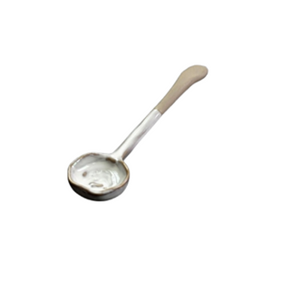Elegant ceramic spoon with hand-glazed finish and painted rim, featuring an organic shape—designed to complement modern artisanal dinnerware.