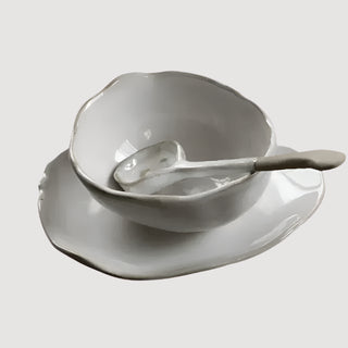 Elegant ceramic spoon with hand-glazed finish and painted rim, featuring an organic shape—designed to complement modern artisanal dinnerware.
