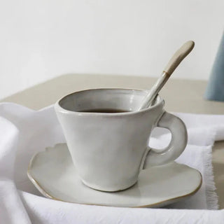 Elegant ceramic spoon with hand-glazed finish and painted rim, featuring an organic shape—designed to complement modern artisanal dinnerware.