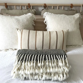 Monochrome merino wool throw styled on a minimalist bed, soft natural blanket for contemporary home decor.