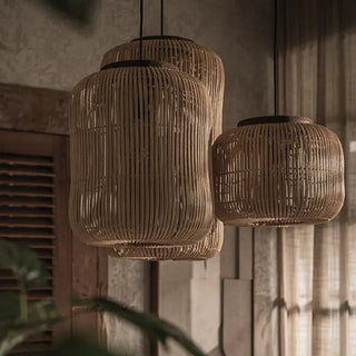 Cluster of natural rattan and teak pendant lights with organic shape — handmade ceiling lamp for minimalist or coastal interiors.