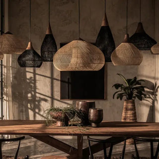 Black and natural handmade rattan and teak pendant light with organic shapes — artisan ceiling lamps for Wabi Sabi or Boho interiors.