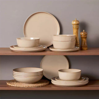 Beige ceramic dinnerware set with glazed finish on open shelving
