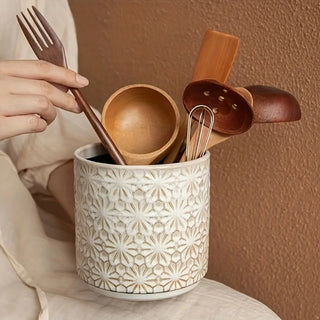 Decorative ceramic countertop caddy holding wooden kitchen tools.