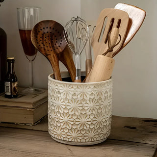 Decorative ceramic countertop caddy for holding wooden kitchen tools.
