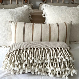 Beige merino wool throw styled on a minimalist bed, soft natural blanket for contemporary home decor.