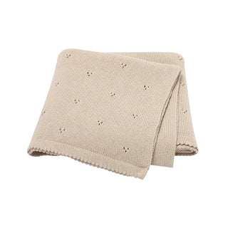 Gigi cotton knit baby blanket folded in soft pastel beige.