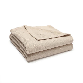 Gigi cotton knit baby blanket folded in soft pastel beige.