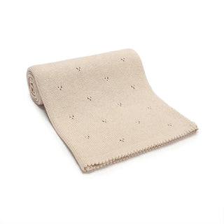 Gigi cotton knit baby blanket folded in soft pastel beige.