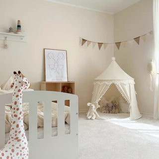 Children's bedroom with a white crib, play tent, and toys.