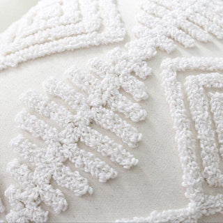 Detail of hand-tufted boho cushion cover with geometric pattern and tassels. Natural home décor accessory for coastal, Scandi and contemporary interiors.