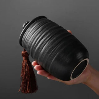 Elegant black ceramic large storage jars in various shapes and sizes, featuring a ribbed textured finish and airtight lids. Perfect for storing tea, coffee, sugar, and spices while adding a modern, sophisticated touch to any kitchen countertop.