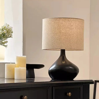 Minimalist table lamp with  asymmetric base and soft warm lighting.