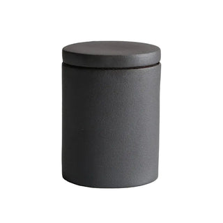 Black ceramic kitchen storage canister with lid, minimalist design.