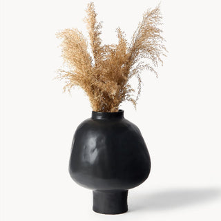 Black ceramic sculptural vase with a minimalist design, available in two sizes that can be styled together. The vase features a creative, artistic shape and a sleek black finish, perfect for adding a bold, statement look to any modern or contemporary interior.