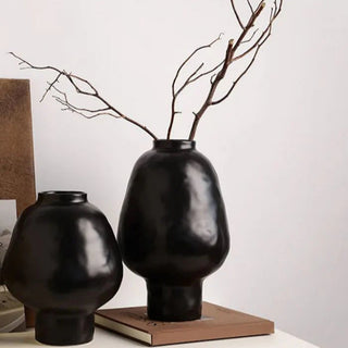 Black ceramic sculptural vase with a minimalist design, available in two sizes that can be styled together. The vase features a creative, artistic shape and a sleek black finish, perfect for adding a bold, statement look to any modern or contemporary interior.