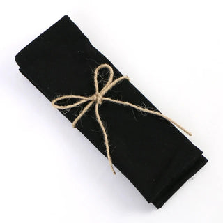 Set of four handmade black cotton table napkins with soft texture and minimalist design, styled for a modern table setting.