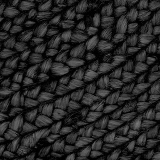 Round black jute rug handwoven with natural braided fibres—minimalist, sustainable, and ideal for Scandi or boho interiors.