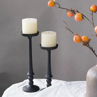 Two black candle holders creating sculptural modern display.