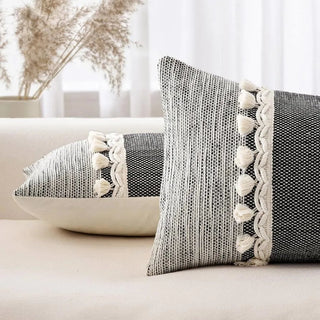 Handwoven cotton lumbar cushion cover with black striped detailing and tassel fringe—ideal for boho or contemporary living spaces.