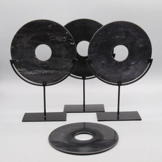 Black marble disc ornament on metal stand, sculptural decor styling for minimalist or modern interiors.