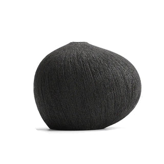 Black textured ceramic vase with a minimalist design, available in two colours that can be styled together. The vase features a creative, organic pebble shape and a black matte finish, perfect for adding a bold, statement look to any modern or contemporary interior.