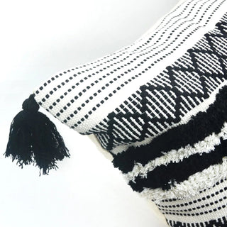 Zohra black and white cotton cushion cover with hand-tufted embroidery and tasselled corners. Moroccan-inspired design for natural and modern décor.