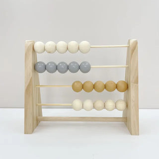Wooden abacus toy with pastel-colored beads, placed on a neutral surface—ideal for counting and sensory play.
