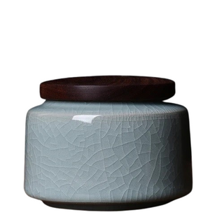 Elegant crackled glaze ceramic storage canister with a dark walnut lid, perfect for kitchen or home organization. Featuring a textured, artisanal design in a soft blue hue, this airtight container is ideal for storing tea, coffee, spices, or small household items. A stylish and functional addition to natural homeware collections.