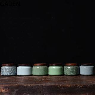 Small blue and green crackled ceramic storage canisters with airtight walnut twist lids, perfect for storing tea, coffee, or spices.