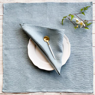 Set of two handmade light grey linen napkins with soft texture and natural drape, styled for an elegant, minimalist table.