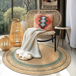 Round handwoven jute rug with concentric two-tone braided design in natural and neutral shades, styled in a boho chic living space.