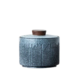 Elegant ceramic tea caddy with a dark walnut lid, perfect for kitchen or home organization. Featuring a textured, artisanal design in a grey blue hue, this airtight container is ideal for storing tea, coffee, spices, or small household items. A stylish and functional kitchen addition to a contemporary, minimalist or Japanese aesthetic.